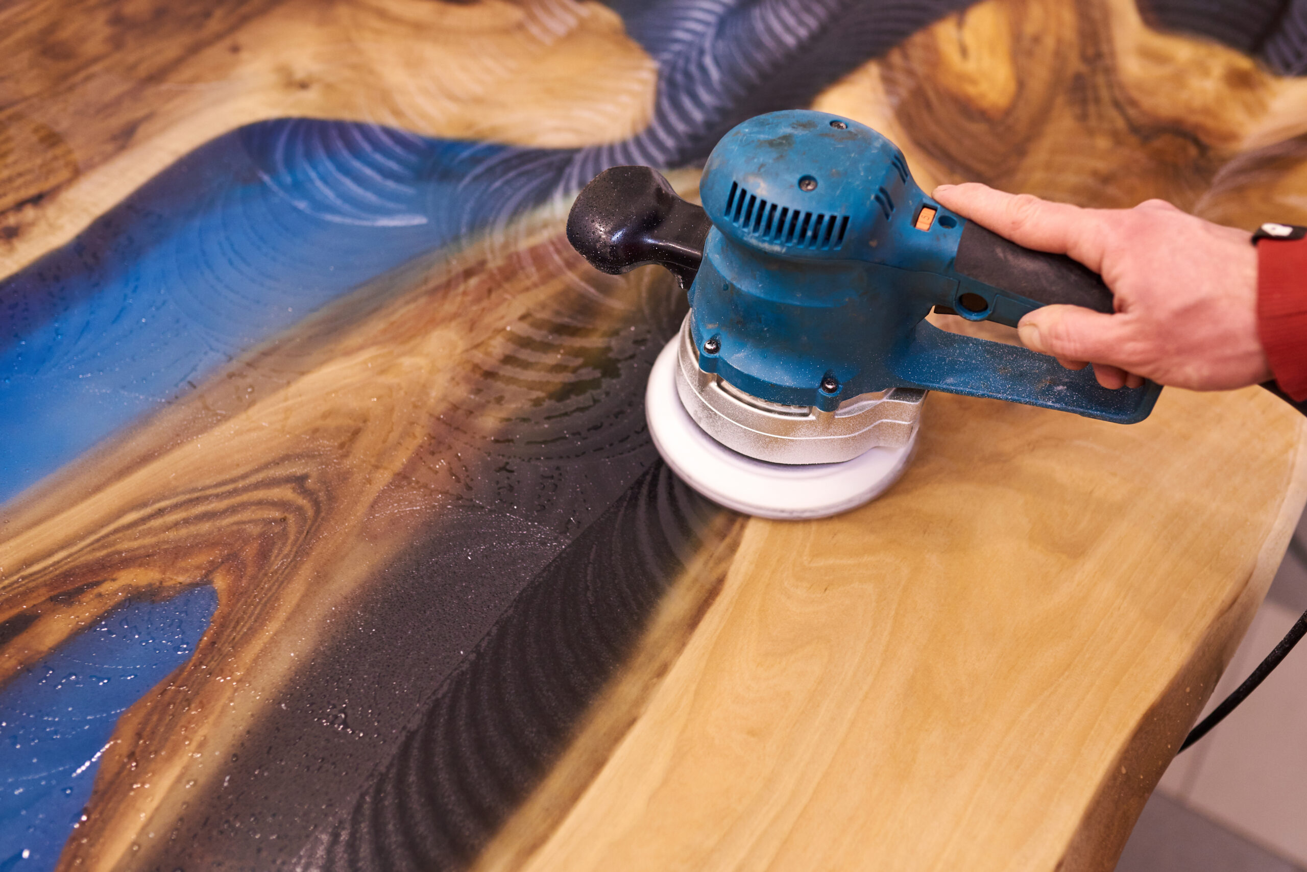 man polishing epoxy table close up.